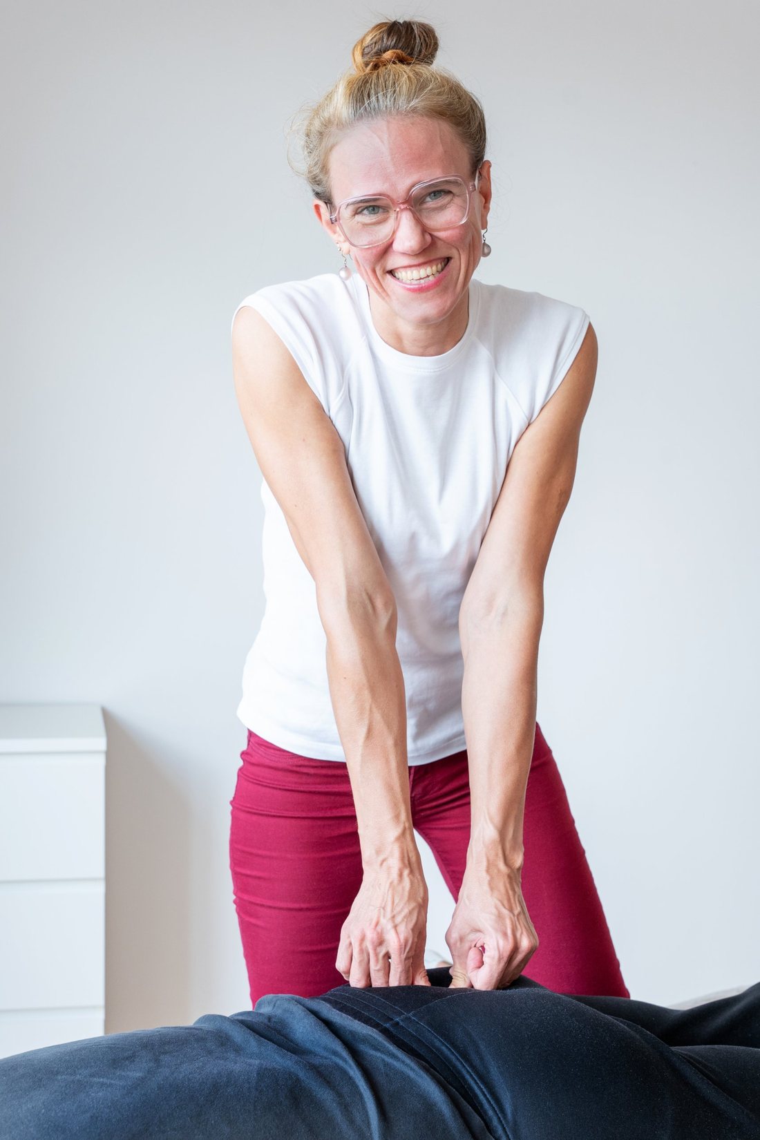 Patricia lächelt, während sie mit beiden Händen am Rücken arbeitet